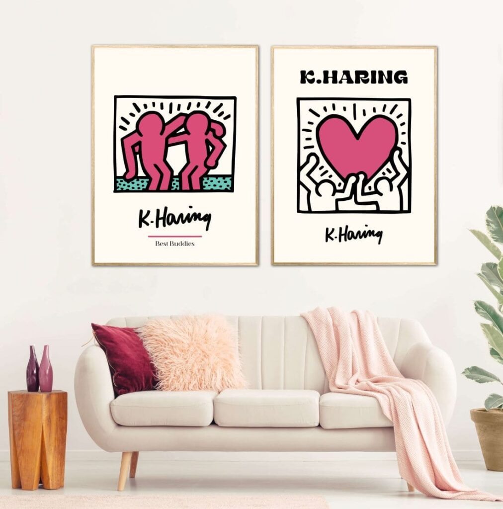 Two Keith Haring cartoons hanging on a wall above a couch