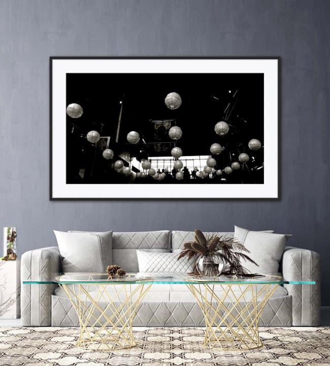Framed black and white photo of the round lamps adorning the ceiling of Little Creatures Brewery in Fremantle Australia. The picture is hanging on a wall above a sofa