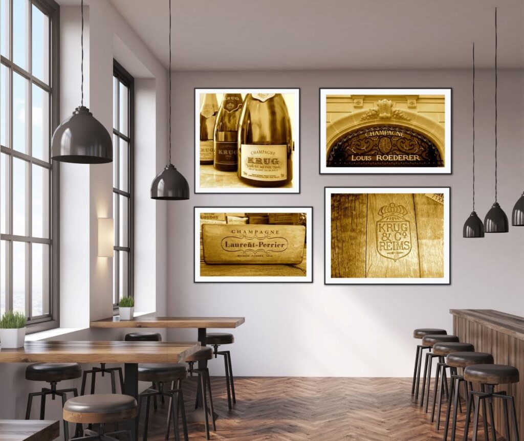 A collage of 4 framed pictures hanging on a wall in a restaurant. 3 of the pictures show champagne labels and one showing 3 bottles of champagne on a table  