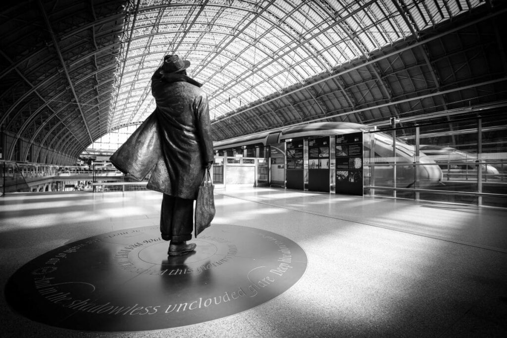 Black and white photo of the statue of Sir John Betjeman at the St Pancreas station.