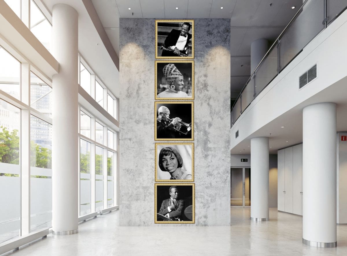 4 gold framed black and white pictures of jazz musicians on a wall