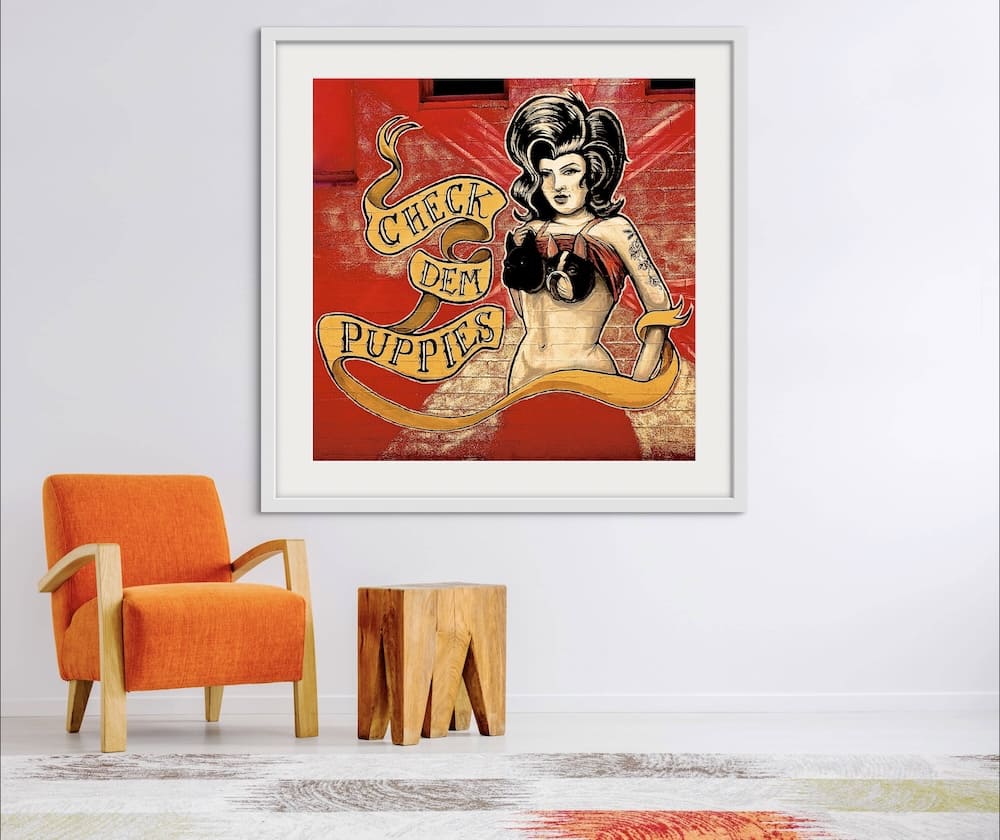 Framed image of a sketch of a woman wearing a bra with dog faces and the image caption reads check dem puppies