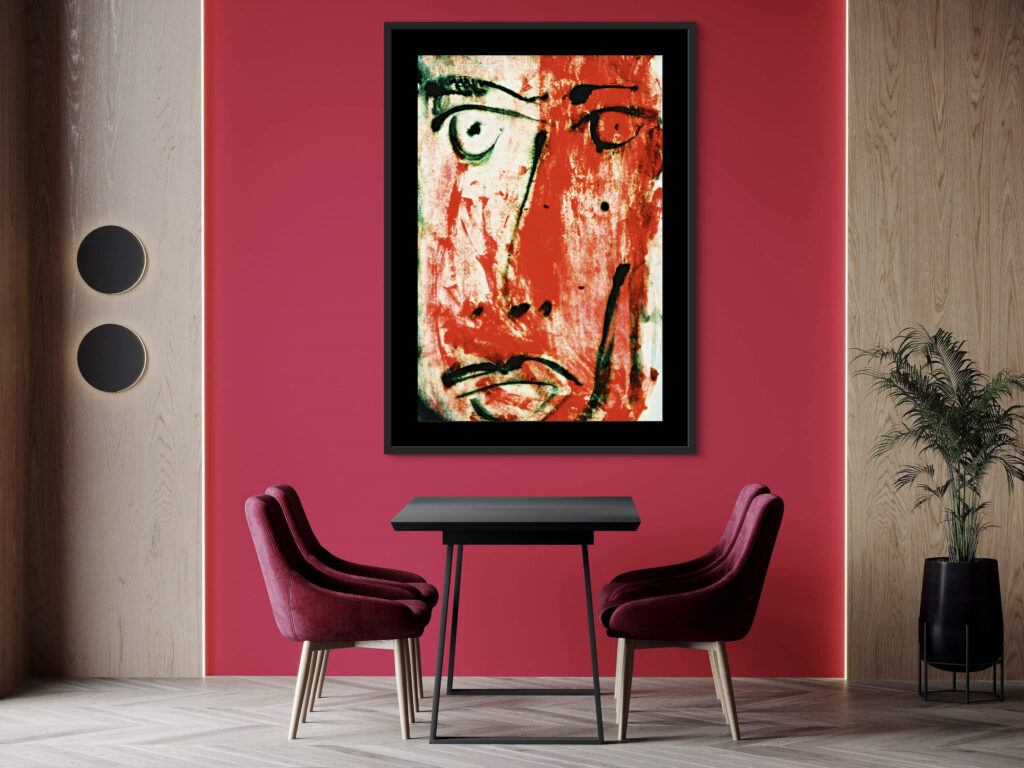 Framed abstract art hanging on a red wall above two chairs and a table.