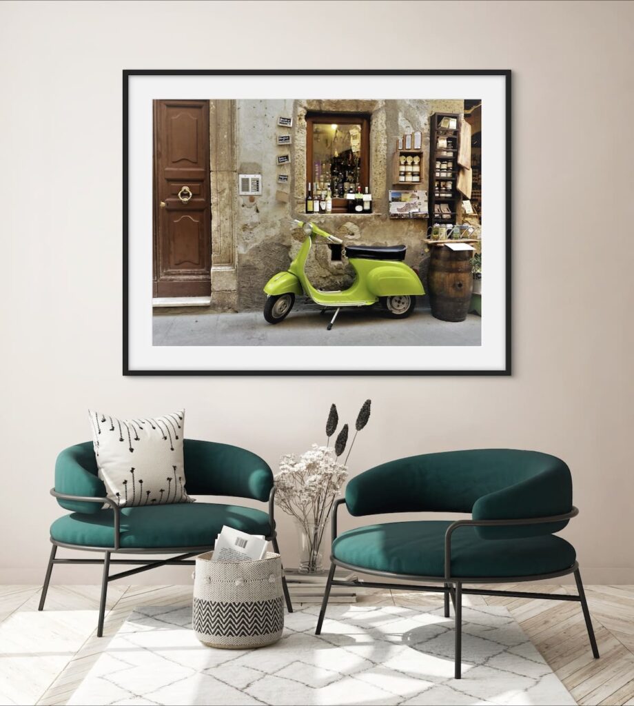 Framed image of a lime coloured Vespa hanging on a wall about two lounge chairs.