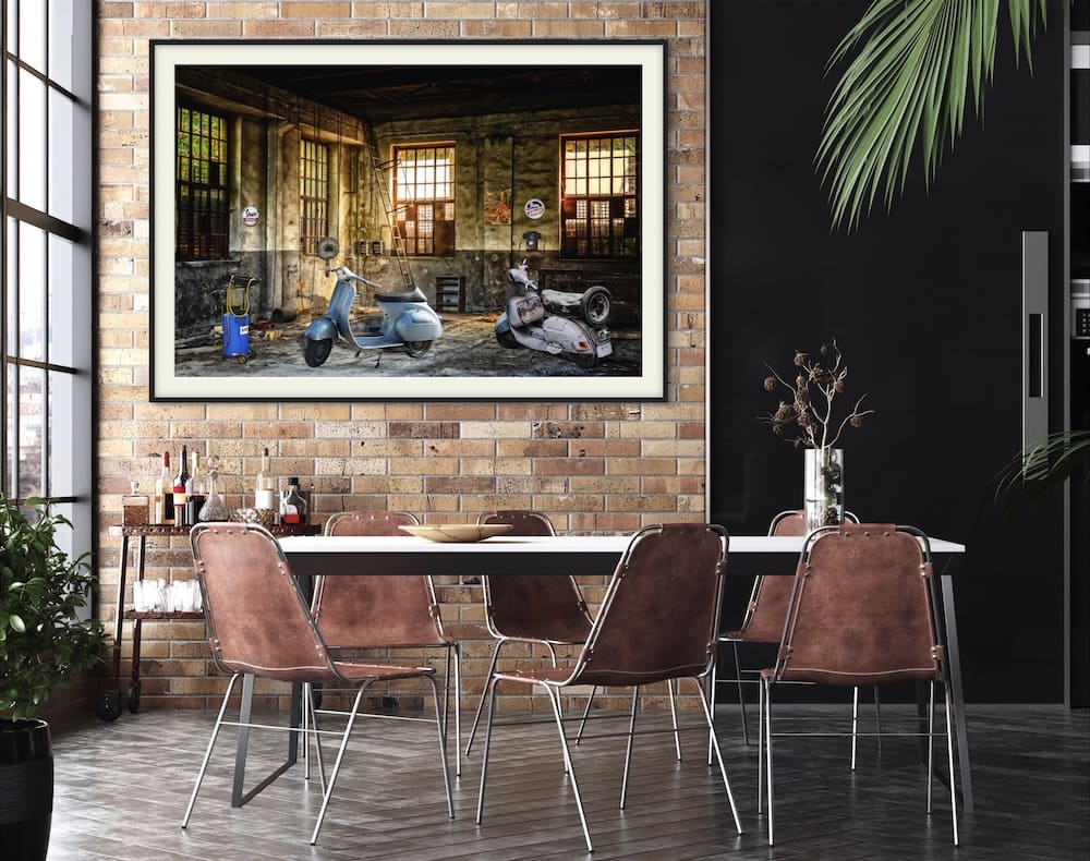 Framed photo showing two Vespas mounted on a brick wall above a dinning room table