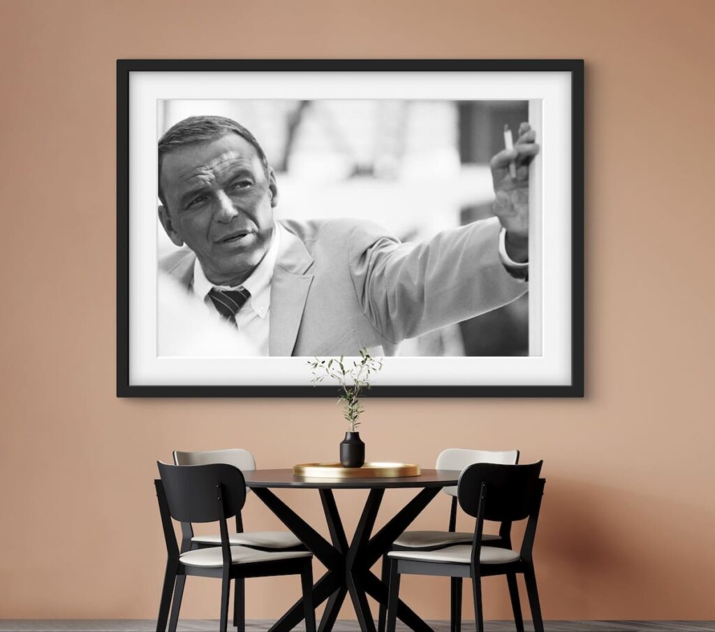 Framed black and white photo of an older Frank Sinatra leaning against a wall with cigarette in hand